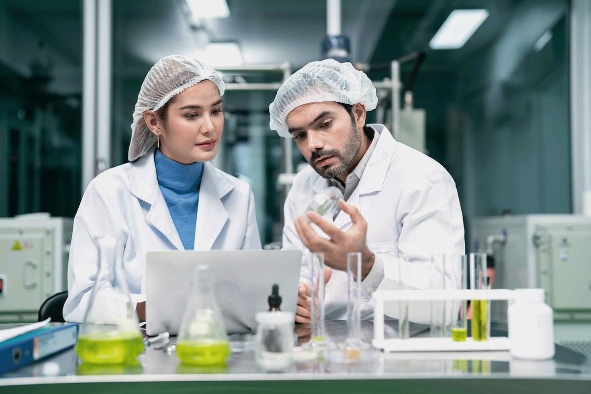 Two medical professionals working in a laboratory wearing medical coats